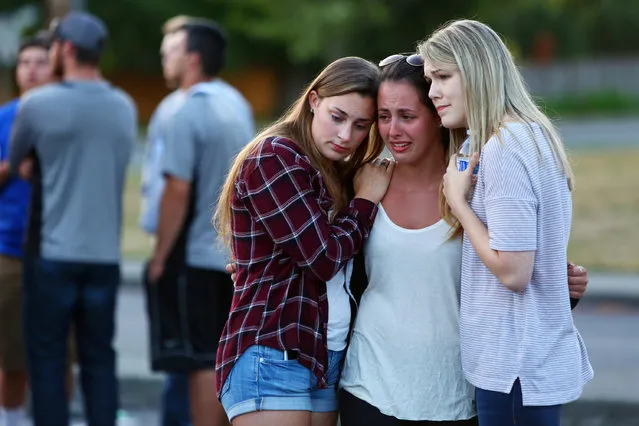 People mourn at a memorial in the parking lot of Kamiak High School Sunday, July 31, 2016, after a community vigil for the victims of a shooting that occurred early Saturday morning at a house in Mukilteo, Wash.,killing three teenagers and wounding one. (Photo by Genna Martin/seattlepi.com via AP Photo)