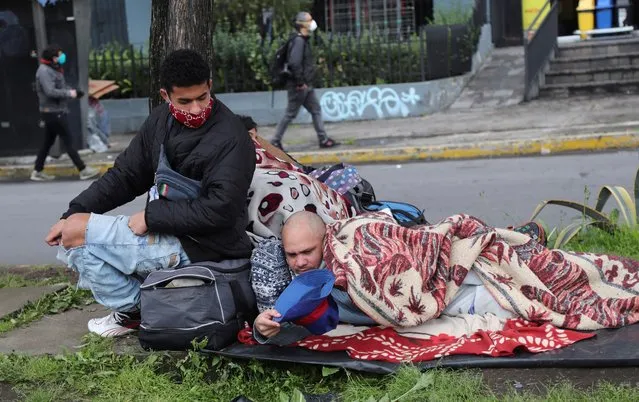 Venezuelans camp outside their embassy in hopes of help from their government to return home, in Quito, Ecuador, Wednesday, May 13, 2020, amid the lockdown to contain the spread of the new coronavirus. The migrants don't have access to the public health system and there is little work amid the shutdown. (Photo by Dolores Ochoa/AP Photo)