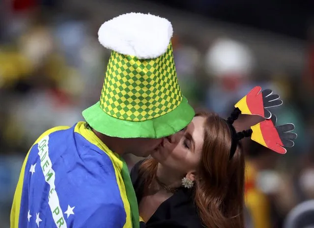 2016 Rio Olympics, Opening ceremony, Maracana, Rio de Janeiro, Brazil on August 6, 2016. A man with a Brazilian flag draped over his shoulders kisses a woman dressed in the colours of the German flag. (Photo by Lucy Nicholson/Reuters)