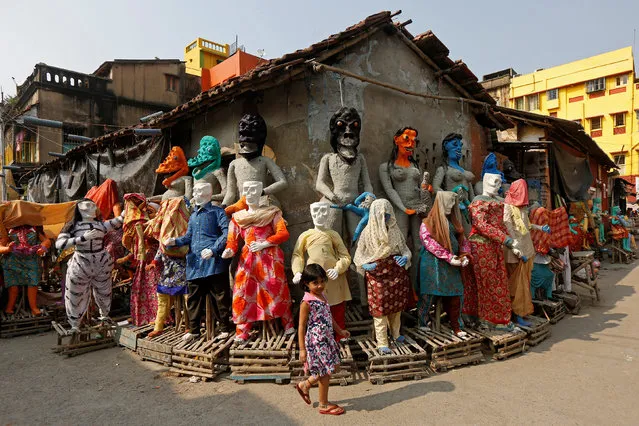 A girl walks past clay idols of the Hindu mythological characters “Dakinis” and “Yoginis”, who will be worshipped along with the Hindu goddess Kali during the Kali Puja festival, at a roadside workshop in Kolkata, October 17, 2017. (Photo by Rupak De Chowdhuri/Reuters)