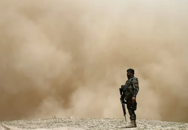 An Afghan National Army (ANA) soldier keeps watch after a helicopter takes off near the landslide site in the Argo district of Badakhshan province May 7, 2014. (Photo by Mohammad Ismail/Reuters)
