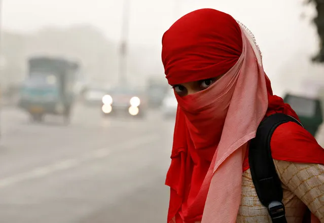 A woman wearing a scarf to cover her face looks on as she waits for a passenger bus on a smoggy morning in New Delhi, India, November 8, 2017. (Photo by Saumya Khandelwal/Reuters)