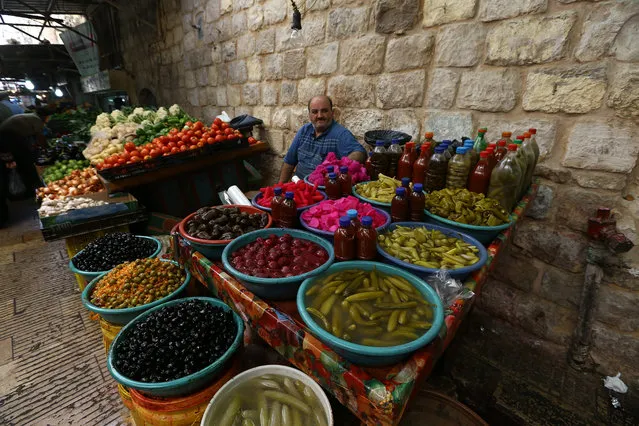 A Palestinian vendor waits for customers in the old market during preparations for the Muslim festival of Eid al-Adha, in the Old City of Nablus, October 2, 2014. Muslims around the world are preparing to celebrate the Eid al-Adha feast by slaughtering cattle, goats and sheep in commemoration of the Prophet Abraham's readiness to sacrifice his son to show obedience to God. (Photo by Alaa Badarneh/EPA)