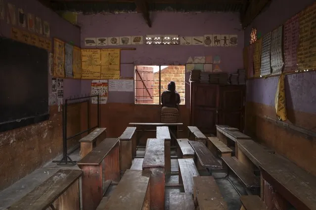 A teacher looks out the window of an empty classroom at the God's Will Primary school, which was closed for the day to mourn the death of a pupil from Ebola, in Kampala, Uganda Thursday, October 27, 2022. Uganda's Ebola outbreak is under control and authorities are doing well to trace most contacts, a top public health official in Africa said Thursday, despite six cases of schoolchildren with the disease in three different schools in the capital, one of whom died. (Photo by Hajarah Nalwadda/AP Photo)