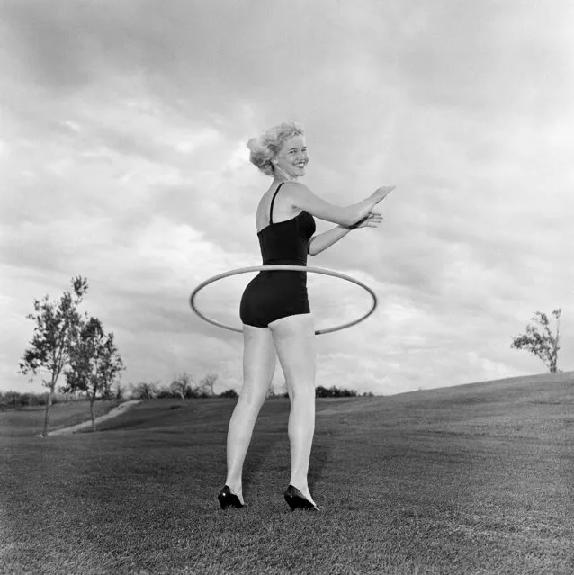 Model Fay Shott spins one of the new plastic Hula Hoops around her waist in Denver; Colo., on August 24, 1958. The hoops are currently popular with the younger crowd. (Photo by John F. Urwiller/AP Photo)