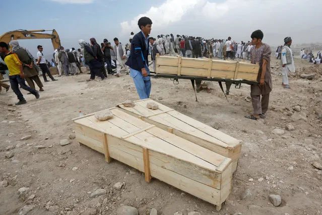 Afghan men carry empty coffins for the victims of yesterday's suicide attack in Kabul, Afghanistan July 24, 2016. (Photo by Omar Sobhani/Reuters)