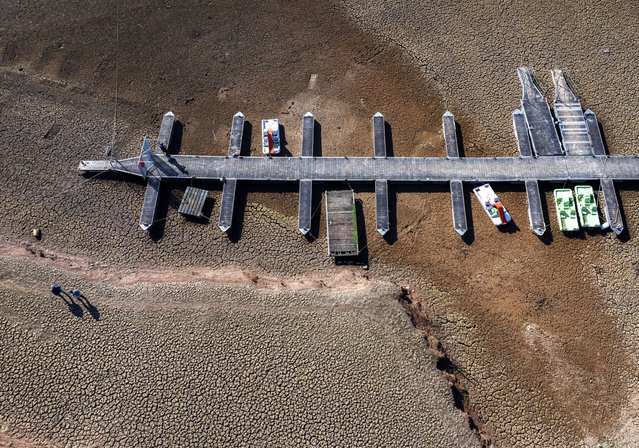 A pontoon mooring recreational boats lies on the dry, cracked ground of the Sau reservoir, which is only at 5% of its capacity, in Vilanova de Sau, about 100 km (62 miles) north of Barcelona, Spain, Friday, January 26, 2024. The northeastern region of Catalonia is one of the two worst-hit regions in a two-year-plus drought affecting most of Spain. Reservoirs in the eastern coastal part of Catalonia are below 16% of their capacity, less than half the current national average, and the region is on the point of declaring a drought emergency and introducing more water restrictions for houses, farmers and industry. (Photo by Emilio Morenatti/AP Photo)