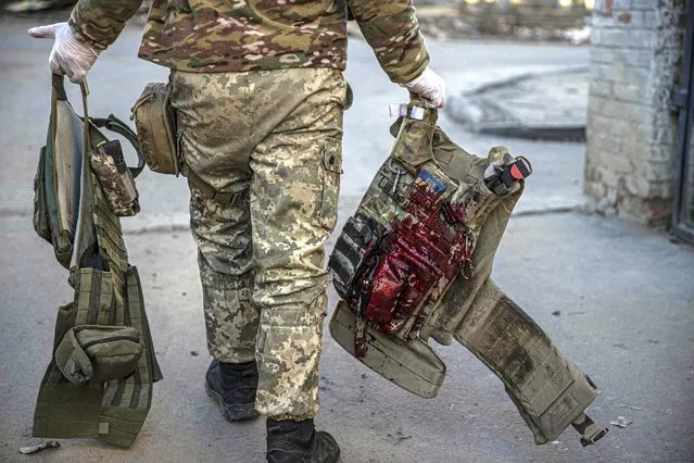 A Ukrainian soldier carries the blood covered vest of another Ukrainian soldier, wounded in conflicts within Russian-Ukrainian war, at Bakhmut Hospital in Bakhmut, Donetsk Oblast, Ukraine on December 5, 2022. (Photo by Metin Aktas/Anadolu Agency via Getty Images)