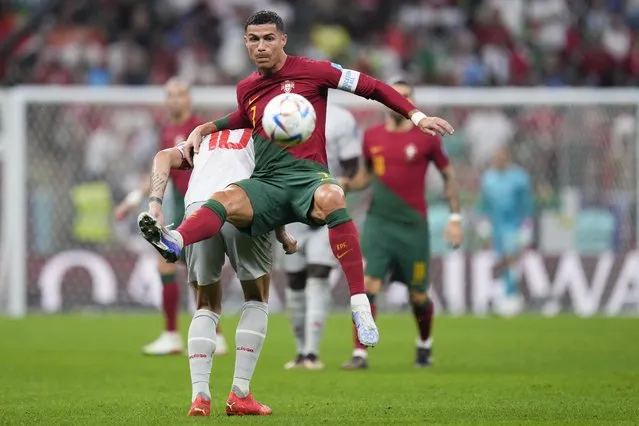 Portugal's Cristiano Ronaldo, front, and Switzerland's Granit Xhaka battle for the ball during the World Cup round of 16 soccer match between Portugal and Switzerland, at the Lusail Stadium in Lusail, Qatar, Tuesday, December 6, 2022. (Photo by Manu Fernandez/AP Photo)