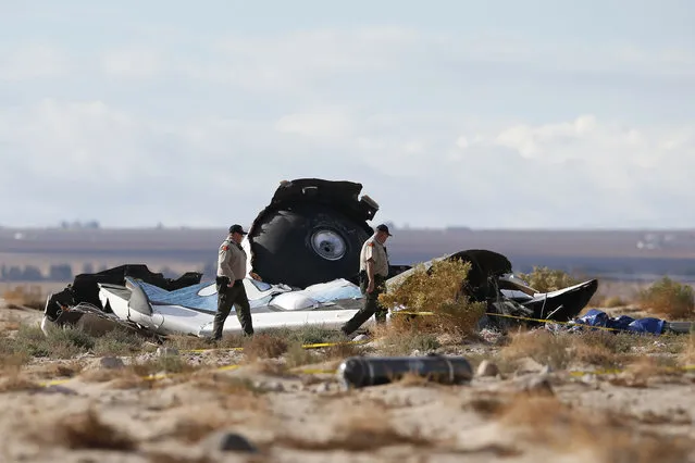 Sheriff's deputies look at a piece of debris near the crash site of Virgin Galactic's SpaceShipTwo near Cantil, California, on November 2, 2014. (Photo by Lucy Nicholson/Reuters)