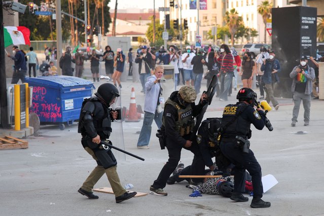 Police detains a protester blocking the garage entrance of the Los Angeles Federal Building following multiple detentions by Immigration and Customs Enforcement (ICE), in downtown Los Angeles, California, U.S., June 6, 2025. (Photo by Daniel Cole/Reuters)