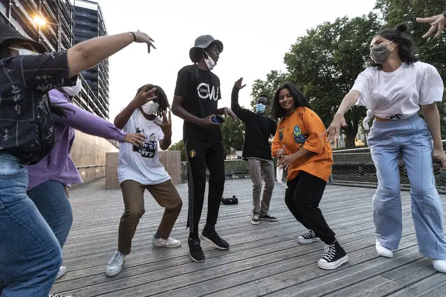 People dance wearing face masks in Strasbourg, eastern France, Friday September 11, 2020. In a speech urging the public to stay “vigilant”, French Prime Minister Jean Castex warned on Friday that the situation is “obviously worsening” as the country sees “a substantial increase” in people hospitalized with the virus. (Photo by Jean-Francois Badias/AP Photo)