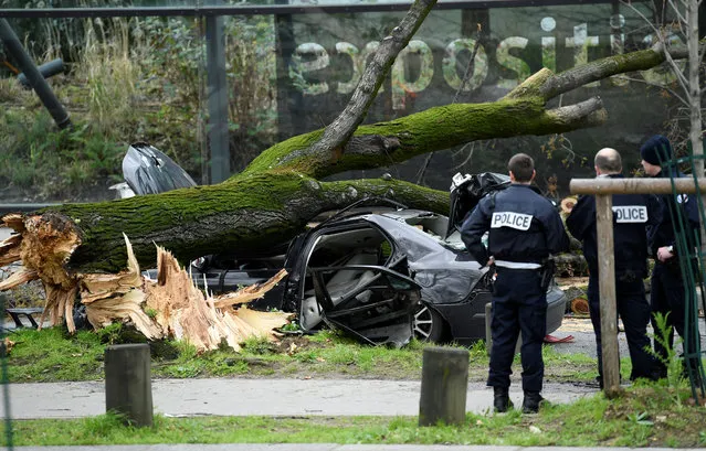 French police forces look at the wreckage of a car which it was damaged by a fallen tree following strong winds, outside the Quai Branly Museum in Paris, on February 27, 2020. (Photo by Bertrand Guay/AFP Photo)
