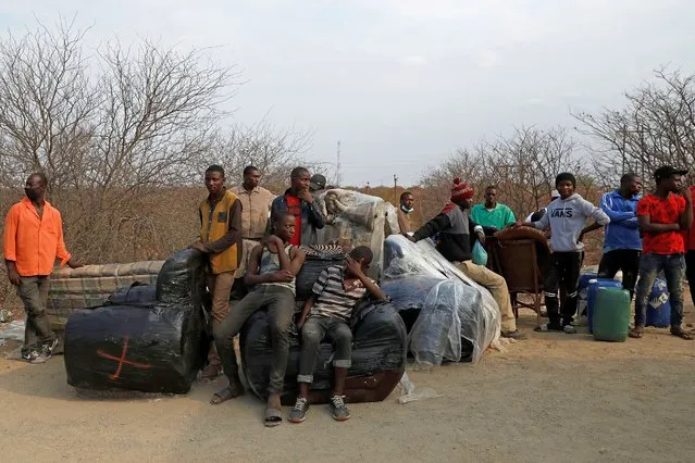 Suspected undocumented Zimbabwean nationals wait to be transported by South African National Defence Force (SANDF) members following their arrest after attempting to smuggle food and furniture into Zimbabwe from South Africa near the Beitbridge border post, near Musina, on October 1, 2020. (Photo by Phill Magakoe/AFP Photo)