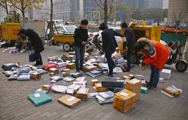 Packages delivered by express companies are laid out to be sorted on a walkway outside a office building in central Beijing November 26, 2014. China should support its e-commerce industry with preferential policies, given the role it plays in stimulating domestic consumption and economic growth, China's State Council said in a paper released on Sunday. (Photo by Petar Kujundzic/Reuters)
