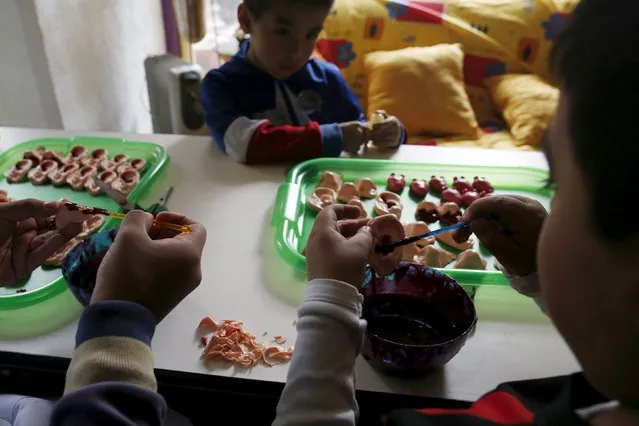 Children use red jelly to paint on ears and noses made of gummy candy at the Zombie Gourmet homemade candy manufacturer on the outskirts of Mexico City October 30, 2015. (Photo by Carlos Jasso/Reuters)