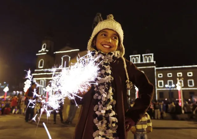 A child holds up a sparkler during Little Candles' Day in Bogota December 7, 2014. The traditional holiday, celebrated on December 7 in Colombia, marks the unofficial start of Christmas in the country. (Photo by John Vizcaino/Reuters)