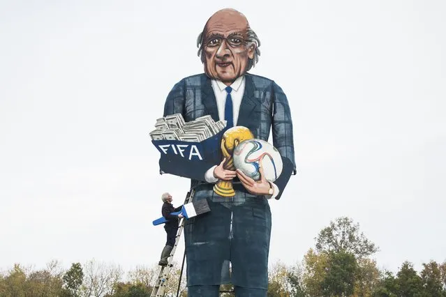 British artist Frank Shepherd of the Edenbridge Bonfire Society poses putting the finishing touches to a giant effigy of the suspended president of FIFA Sepp Blatter in Edenbridge, Kent, southeast England, on November 4, 2015 that will be exploded and burned at this year's Bonfire Night celebrations. (Photo by Jack Taylor/AFP Photo)