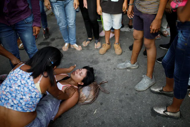 A relative of inmates at the General Command of the Carabobo Police faints outside the prison where a fire occurred in Valencia, Venezuela on March 29, 2018. (Photo by Carlos Garcia Rawlins/Reuters)