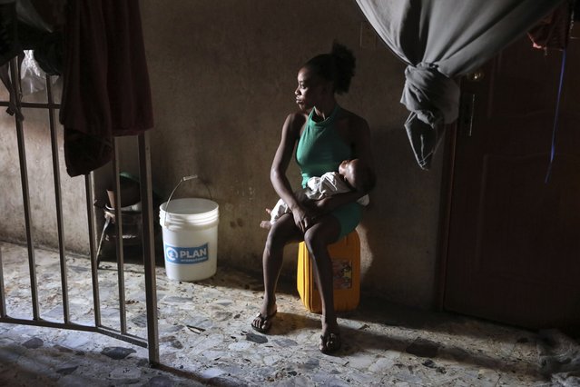 A displaced woman holds her baby inside a school that is now operating as a shelter for those fleeing their homes to escape gang violence in Port-au-Prince, Haiti, Monday, April 14, 2025. (Photo by Odelyn Joseph/AP Photo)