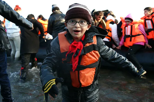 A boy runs ashore after making the crossing from Turkey to the Greek island of Lesbos on November 17, 2015 in Sikaminias, Greece. Rafts and boats continue to make the journey from Turkey to Lesbos each day as thousands flee conflict in Iraq, Syria, Afghanistan and other countries. (Photo by Carl Court/Getty Images)