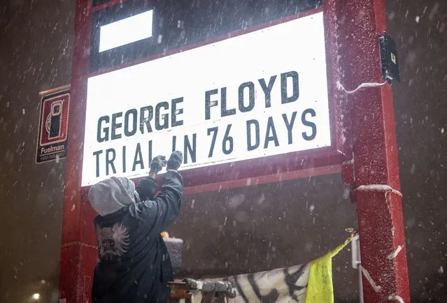 Billy Briggs changes a sign to read “George Floyd Trial In 76 Days” during a snowstorm at George Floyd Square on December 23, 2020 in Minneapolis, Minnesota. Mid-forties temperatures this morning are giving way to high speed wind, low temperatures, and heavy snowfall, as blizzard warnings blanket the state. (Photo by Stephen Maturen/Getty Images)