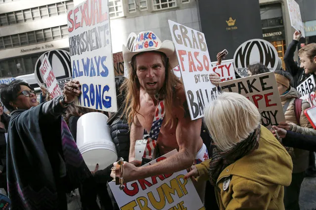 Women hold up signs as they surround Robert Burck, known as the original “Naked Cowboy” who is a supporter of Republican U.S. presidential nominee Donald Trump as they protest against Trump during a demonstration organized by the National Organization for Women (NOW) outside Trump Tower in the Manhattan borough of New York City, October 26, 2016. (Photo by Mike Segar/Reuters)