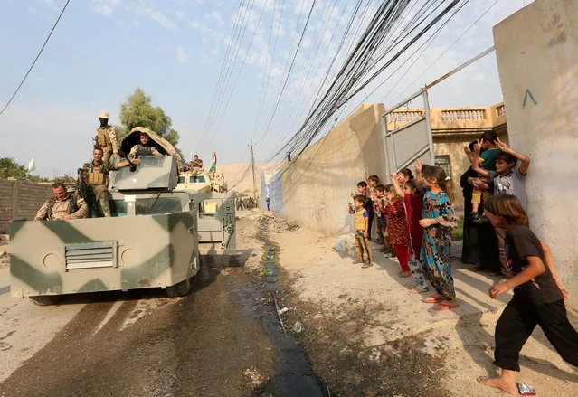 Children welcome Kurdish Peshmerga fighters after peshmerga recaptured from Islamic state militant, the Fadiliya village in Nawaran, north of Mosul, Iraq, October 27, 2016. (Photo by Air Jalal/Reuters)