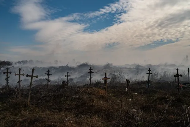 A cloud of smoke is rising at cemetery due to the Russian shelling in Mykolaiv, Ukraine, Monday, March 21, 2022. (Photo by Salwan Georges/The Washington Post)