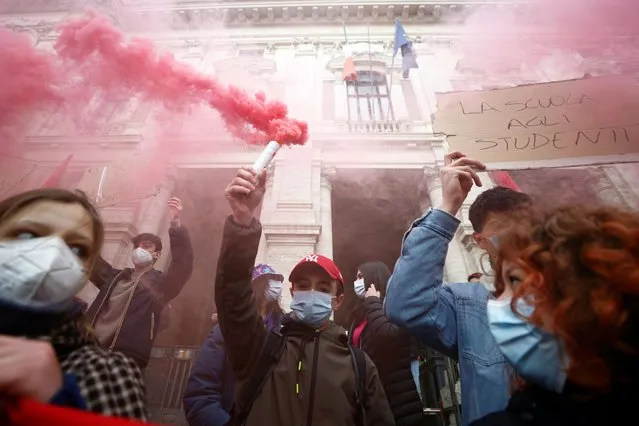 A student holding a smoke flare protests over the decision to keep high schools closed as part of efforts to curb the spread of the coronavirus disease (COVID-19) in Rome, Italy, January 11, 2021. (Photo by Guglielmo Mangiapane/Reuters)