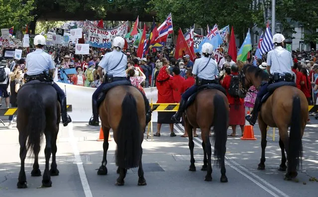 Mounted police form a cordon as protesters march during a rally held ahead of the 2015 Paris Climate Change Conference, known as the COP21 summit, in Sydney's central business district, Australia November 29, 2015. (Photo by Jason Reed/Reuters)