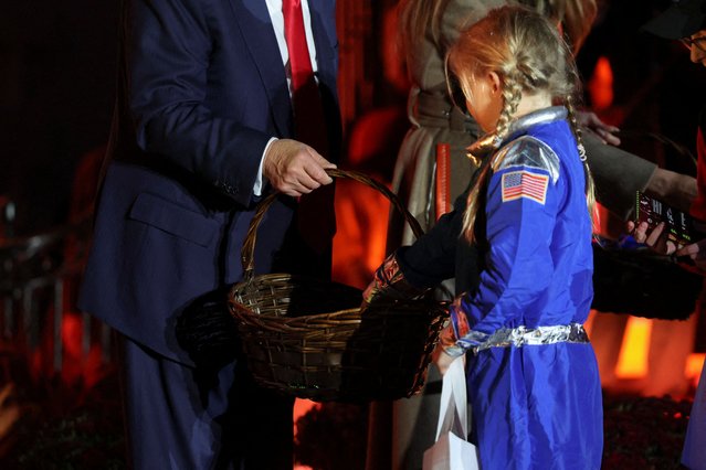 President Donald Trump and first lady Melania Trump give out treats to children during a Halloween event at the White House in Washington, D.C. on October 30, 2025. (Photo by Kylie Cooper/Reuters)