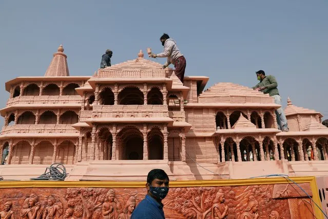 Workers give finishing touches to the model of the proposed Ram temple that Hindu groups want to build at a religious site in Ayodhya, on a tableau during a media preview of tableaux participating in the Republic Day parade in New Delhi, India on January 22, 2021. (Photo by Anushree Fadnavis/Reuters)