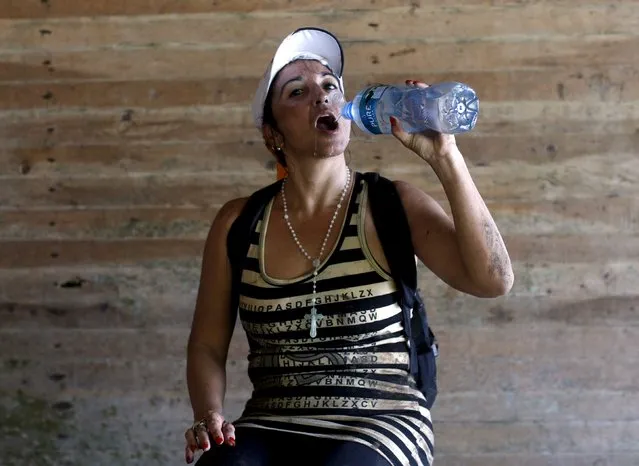 Cuban Roxana Perez, 44, a draftswoman, drinks water as she poses for a photograph after she crossed the border from Colombia through the jungle into La Miel, in the province of Guna Yala, Panama December 2, 2015. (Photo by Carlos Jasso/Reuters)