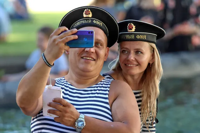 A man and a woman take a selfie on Russian Navy Day in St Petersburg, Russia on July 26, 2020. (Photo by Roman Pimenov/TASS)