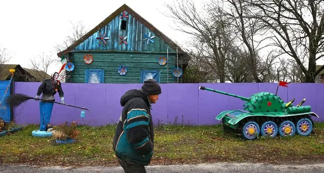 A man walks in front of an installations with Baba Yaga, the Witch, an old woman from Russian fairy tales and a small copy of a tank at a villager's house in the village of Vits, Belarus November 8, 2016. (Photo by Vasily Fedosenko/Reuters)