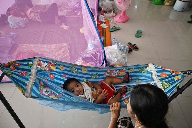 Displaced residents rest at an evacuation center in the Thai border province of Surin on December 12, 2025. At least 20 people have been killed in the latest round of border fighting that reignited last week, officials said. (Photo by Lillian Suwanrumpha/AFP Photo)