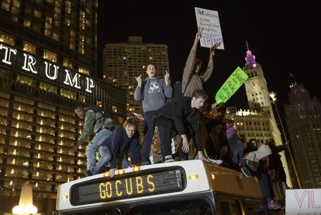 Demostrators protest on top of a bus outside of the Trump Tower November 9, 2016 in Chicago, Illinois. Thousands of people in several cities across the country took to the streets a day after Donald Trump was elected president. (Photo by John Gress/Getty Images)