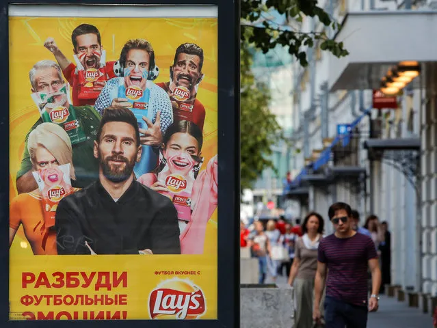 People walk past an advertisement poster depicting Argentina's soccer player Lionel Messi in Moscow, Russia June 20, 2018. (Photo by Sergei Karpukhin/Reuters)