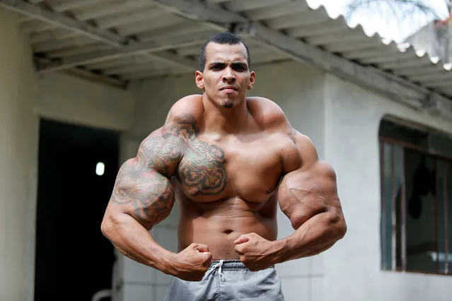 Romario dos Santos Alves, a bodybuilding enthusiast, at his home on April 04, 2015, in Caldas Novas, Goias, Brazil. Bodybuilder Romario Dos Santos Alves modeled himself on the Incredible Hulk and risked his life injecting oil into his arms. The 25-year-old turned to a cocktail of oil, painkillers and alcohol to pump up his biceps – with astounding results. (Photo by Pedro Ladeira/Barcroft USA)