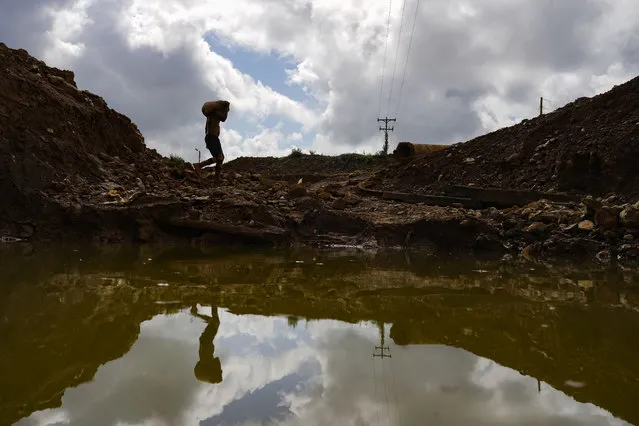 A gold miner carries a sack of rocks to a grinding mill at a mine in El Callao, Bolivar state, Venezuela, Saturday, April 29, 2023. (Photo by Matias Delacroix/AP Photo)