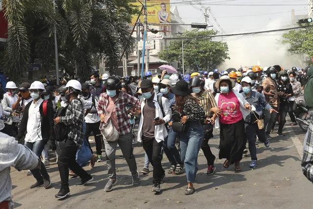 Protesters disperse as police fire tear gas during an anti-coup demonstration in Mandalay, Myanmar, Sunday, March 7, 2021. (Photo by AP Photo/Stringer)