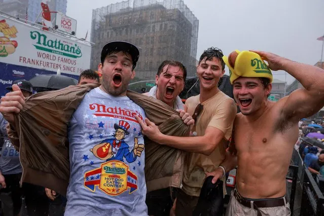 People react as rain falls on the day of the 2023 Nathan's Famous Fourth of July International Hot Dog Eating Contest at Coney Island in New York City, U.S., July 4, 2023. (Photo by Amr Alfiky/Reuters)