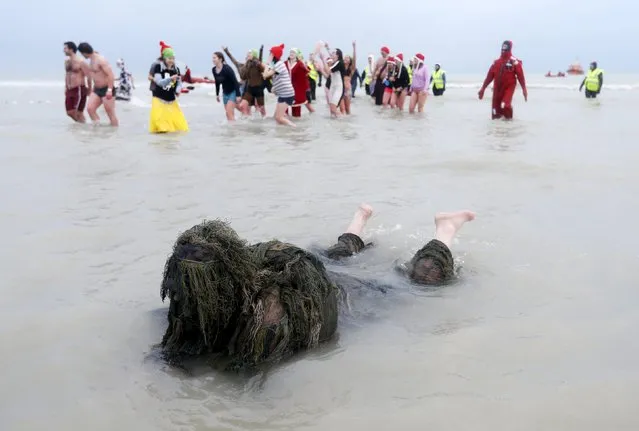 A participant in fancy dress swims in the waters of the North Sea during the annual New Year's plunge event in Ostend, Belgium, January 2, 2016. (Photo by Francois Lenoir/Reuters)