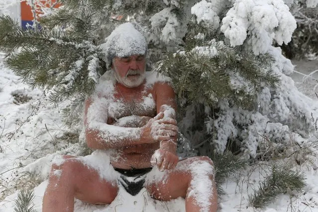 Nikolai Bocharov, 77, a member of the Cryophile winter swimmers club, rubs snow on his body as he sits on a snowdrift after bathing in the icy water of the Yenisei River in the Siberian city of Krasnoyarsk, Russia, November 21, 2015. The air temperature was around minus 27 degrees Celsius. Bocharov started winter swimming while doing military service in Germany. "When I came home from the army, I made an ice hole in the Yenisei and bathed there," he says. (Photo by Ilya Naymushin/Reuters)