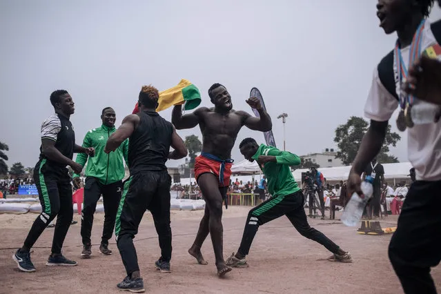 Senegal's Modou Faye (3rdR) celebrates with members of the Senegalese wrestling team at the African traditional wrestling men's final during the 9th Francophone Games in Kinshasa, on August 5, 2023. Sports delegations and residents gathered in Kinshasa's Tata Raphaël stadium on August 5, 2023 to attend the African traditional wrestling men's final, on the eve of the 9th Jeux de la Francophonie closing ceremony. (Photo by Alexis Huguet/AFP Photo)
