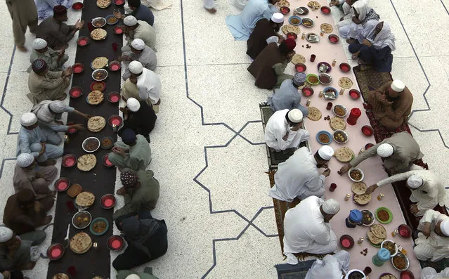 People break their fast during the Muslim holy fasting month of Ramadan, at a mosque in Peshawar, Pakistan, Wednesday, April 14, 2021. Ramadan is marked by daily fasting from dawn to sunset. (Photo by Muhammad Sajjad/AP Photo)