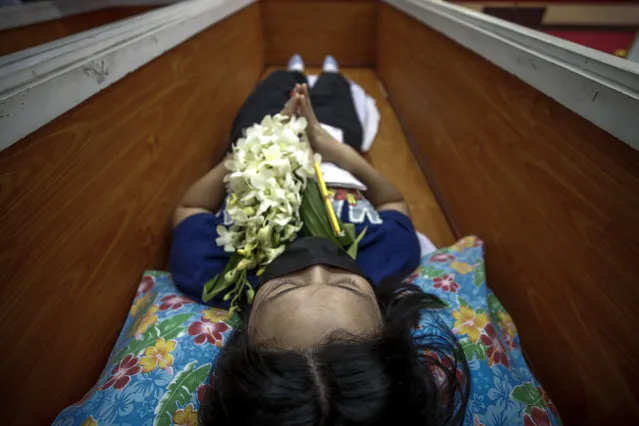A Buddhist devotee lies inside a coffin during a “live funeral” ritual at Bangna Nai temple in Bangkok, Thailand, 13 February 2021. (Photo by Diego Azubel/EPA/EFE)