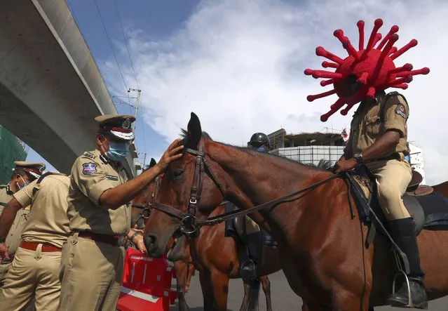 A policeman rides a horse wearing a virus-themed helmet during a COVID-19 awareness drive in Hyderabad, India, Tuesday, June 1, 2021. (Photo by Mahesh Kumar A./AP Photo)