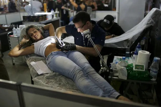 An artist works on a tattoo on a woman's belly during the third International Tattoo Week Rio 2016 festival in Rio de Janeiro, Brazil, January 22, 2016. (Photo by Pilar Olivares/Reuters)